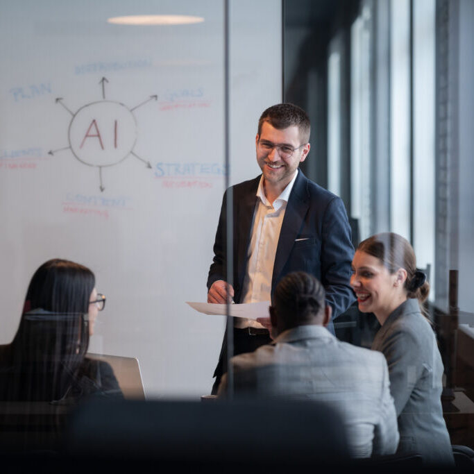 Diverse business team in a modern office during a meeting, discussing artificial intelligence strategy. Concept of AI innovation, teamwork, leadership, corporate planning, professional collaboration.
